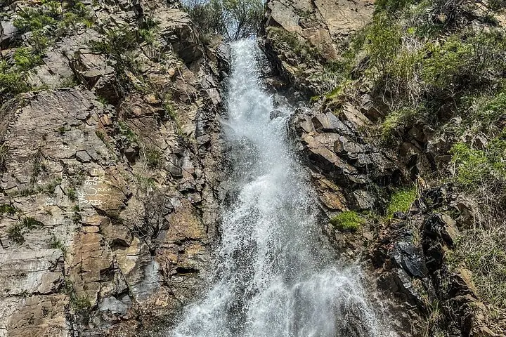 Nahaufnahme eines Wasserfalls, der über felsiges Gelände stürzt.