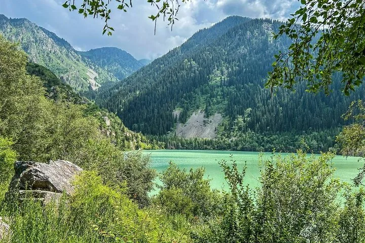 Malerischer Blick auf den Issyk-See, eingebettet in bewaldete Berge.