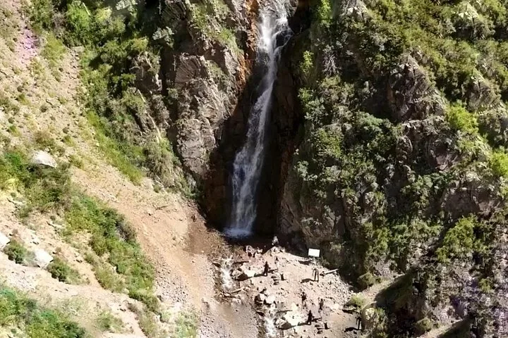 Luftaufnahme eines Wasserfalls, der eine felsige Klippe hinabstürzt.